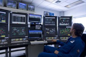 Un operador de panel (o panelista) en su puesto de trabajo utilizando un DCS para monitorizar un proceso industrial