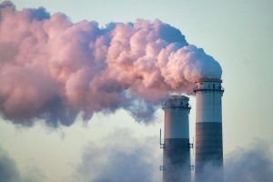 Chimeneas arrojando humo en un complejo industrial